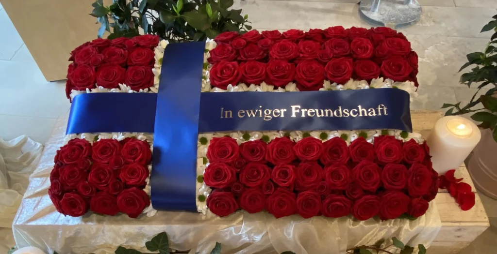Rosenkissen aus roten Rosen mit Trauerschleife